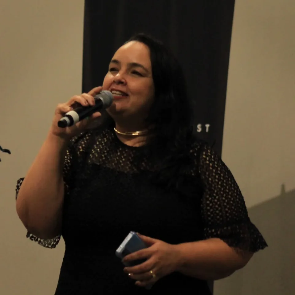 Renata Fernandes fala ao microfone durante uma ministração